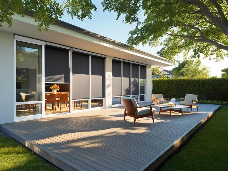 Sunlit home exterior with solar shades and UV-tinted windows on sunny afternoon.